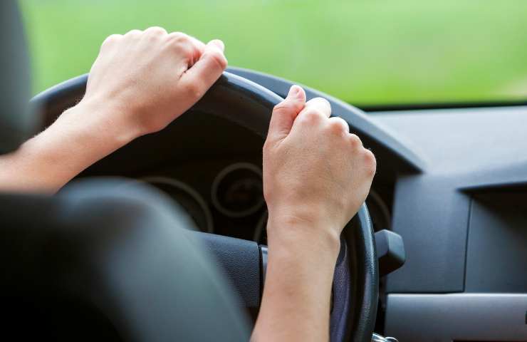 mani di una donna sul volante dell'auto